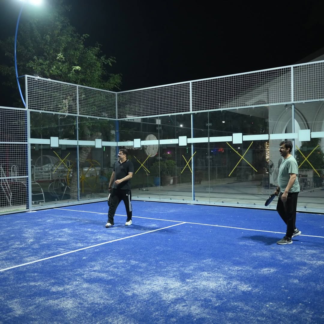 Padel court at night with members warming up